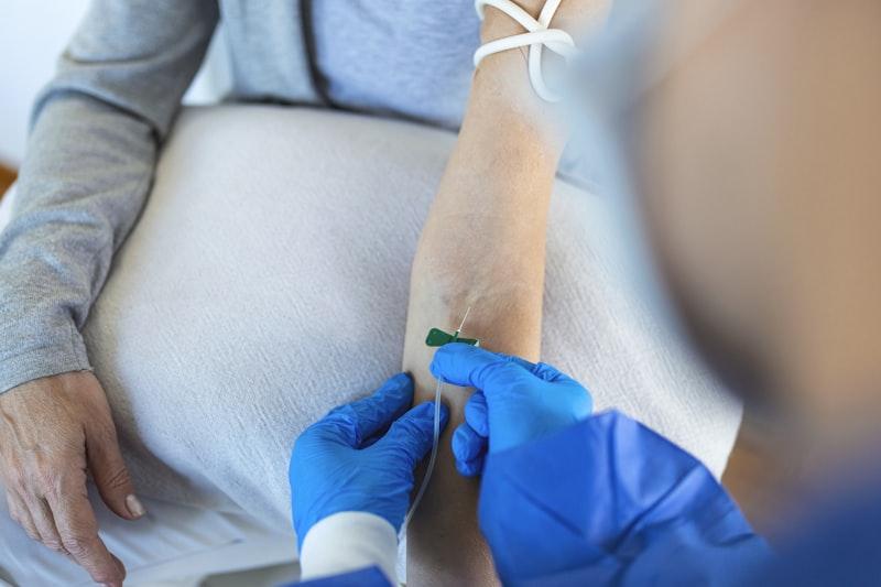 Clinician starting an IV in a patient's arm during a wellness visit